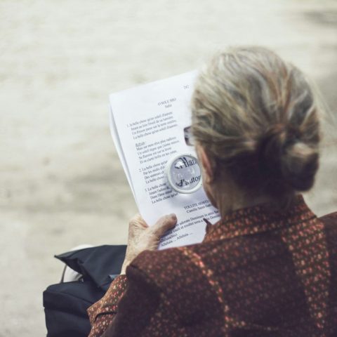 woman in brown top reading paper