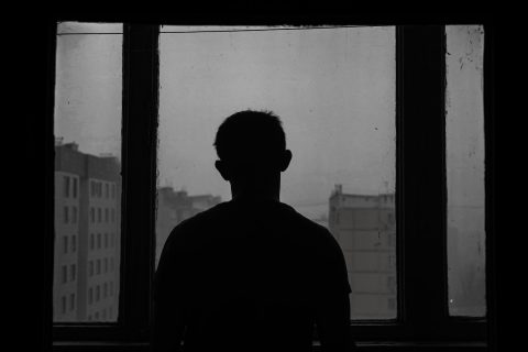 silhouette of man standing near window